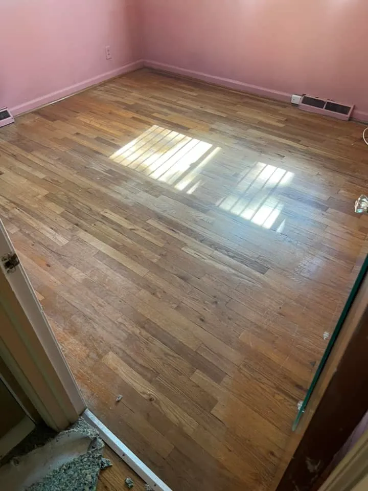 Worn floor after carpet removal, before refinishing